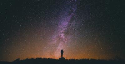 Silhouette of a person with the night sky behind them.