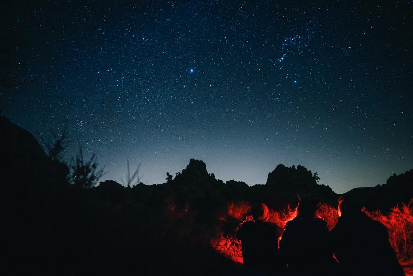 Three friends silhouetted against the night sky